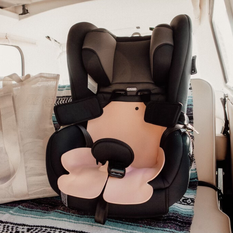 The Coral Pink Sande Kids™ Waterproof Car Seat and Pram liner shown in a child's forward-facing car seat on the back seat of a 1970s kombi