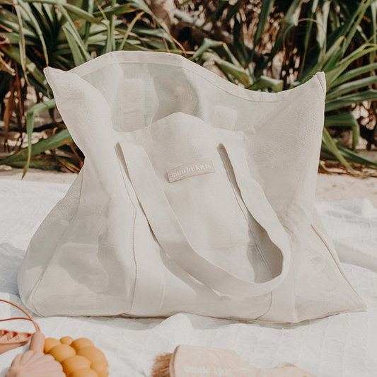 Oversized large mesh beach bag - the Sande Kids Beach Hauler™ with pandanus in the background